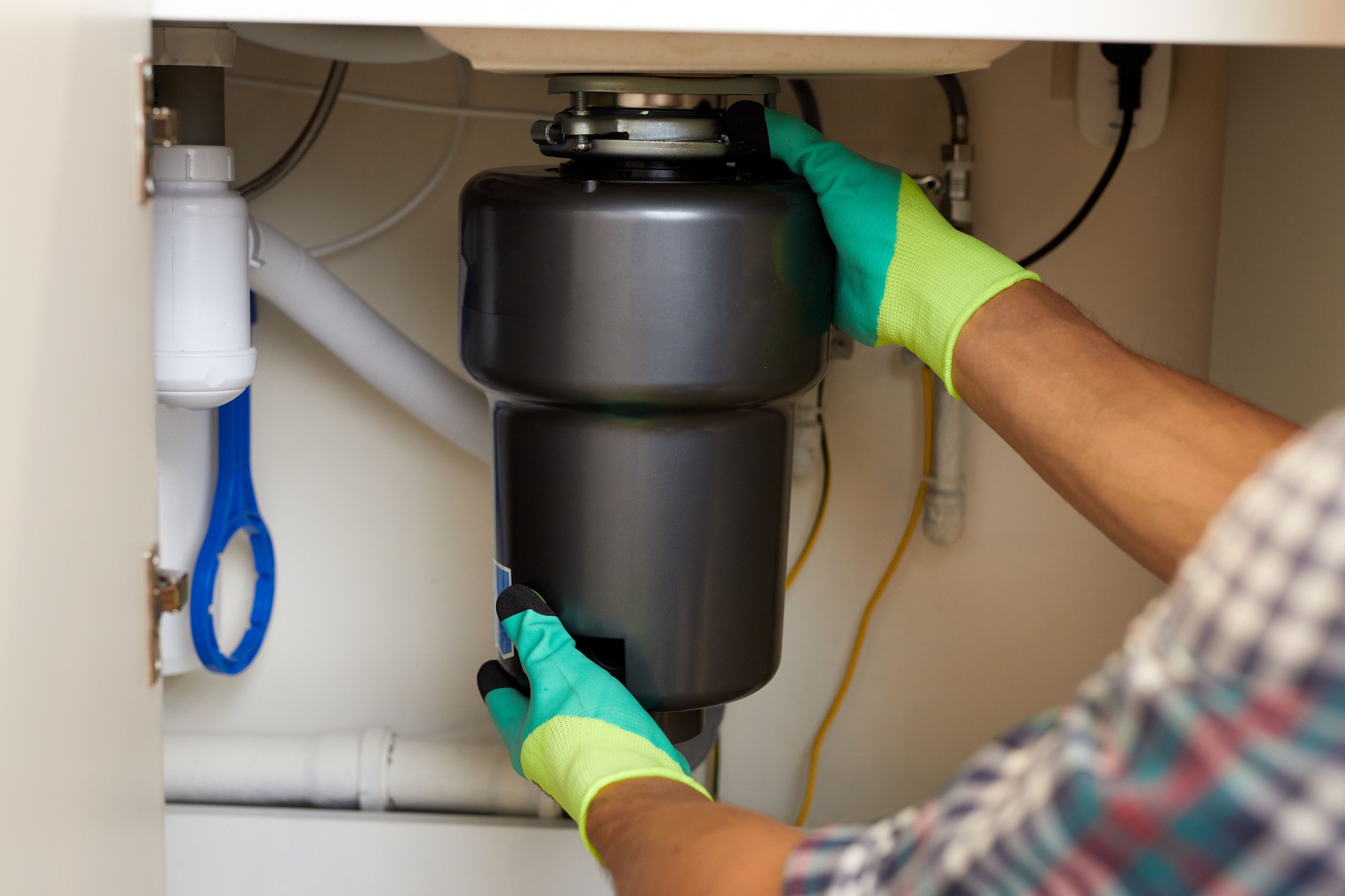 Repair Technician Installing a Kitchen Garbage Disposal Unit Under the Sink For Efficient Waste Management